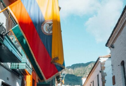 Weathered Ecuadorian flag on a building's balcony